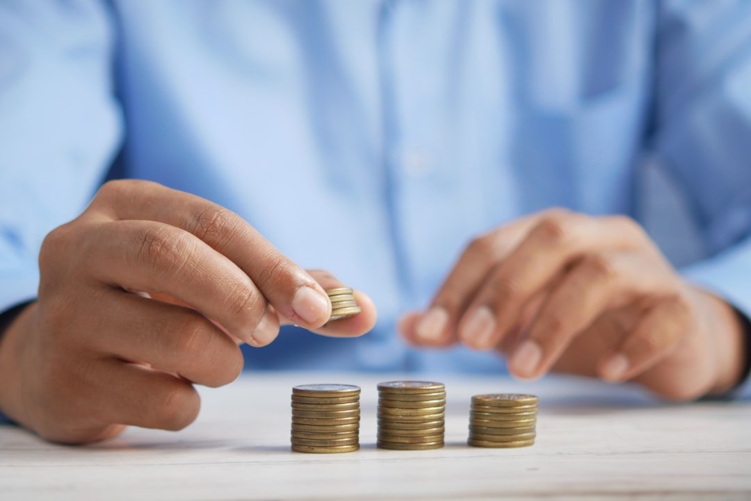 a-person-stacking-coins-on-top-of-a-table-jpqyfk7gb4w