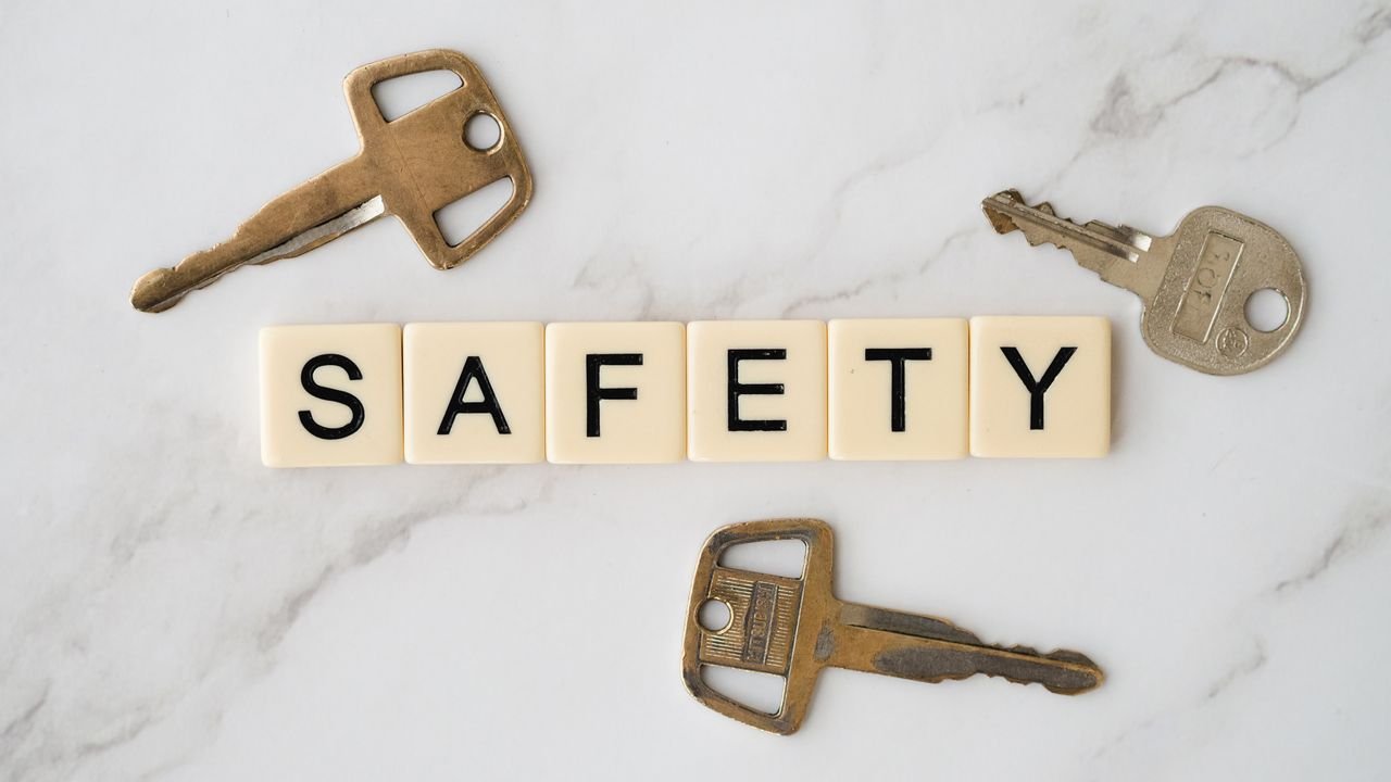 services-06 Close-up image of keys and scrabble tiles spelling 'safety' on a marble surface.